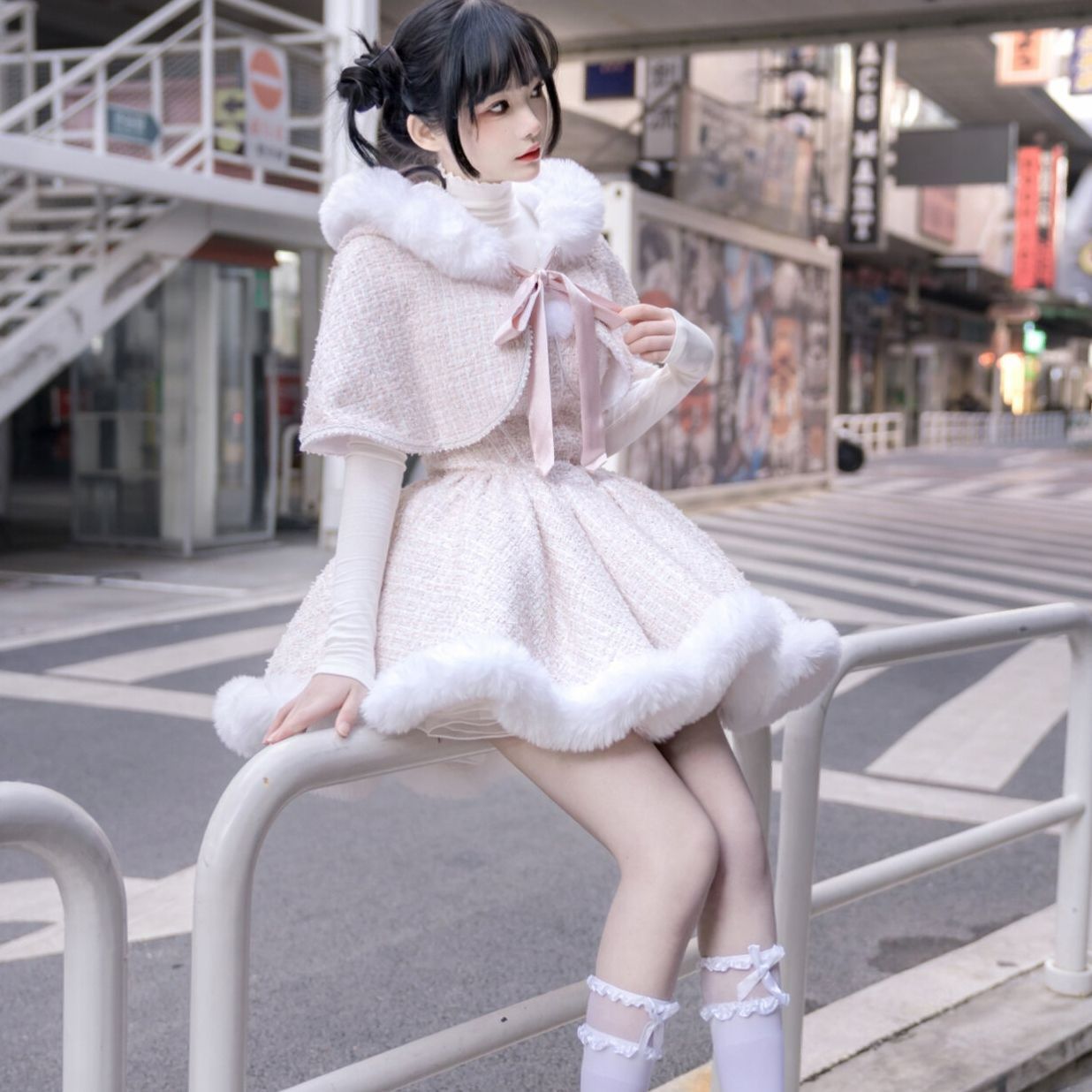 Pale pink hooded cape dress with white faux-fur trim and a pink ribbon bow