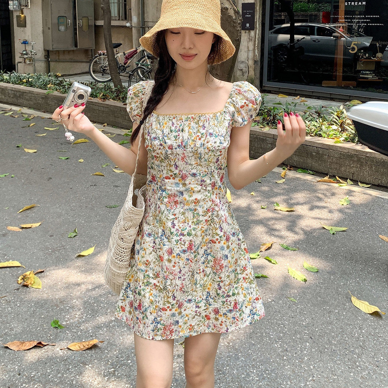 Model wearing a white multicolor floral mini dress with puff sleeves and square neckline